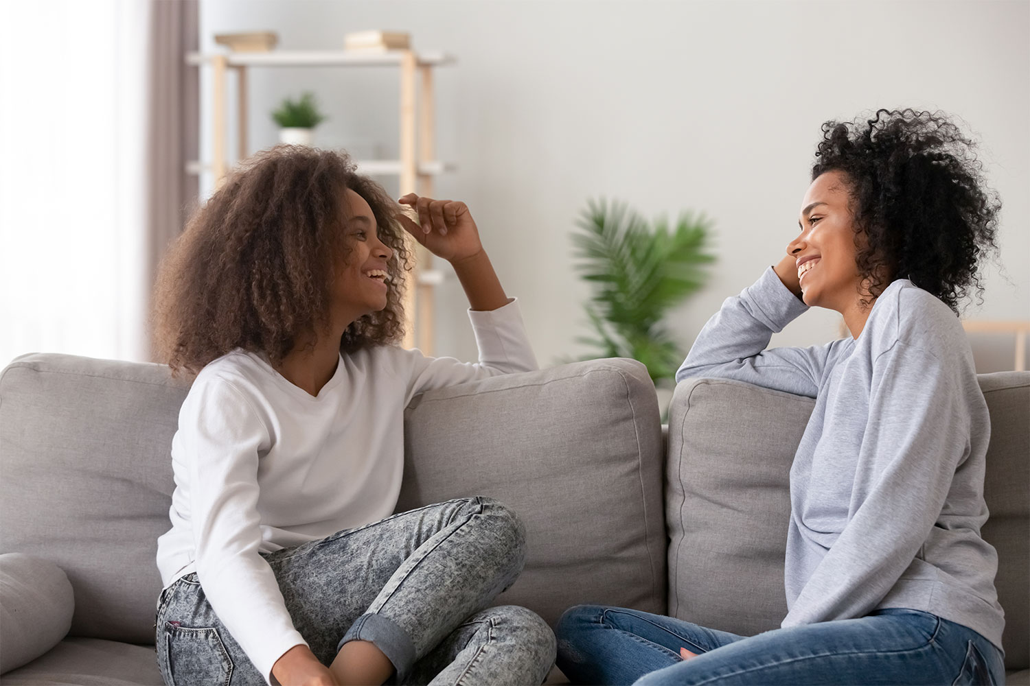 Parent and teen talking while sitting on the couch.