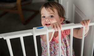 toddler at plastic baby gate