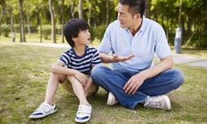 Father talking with son at park