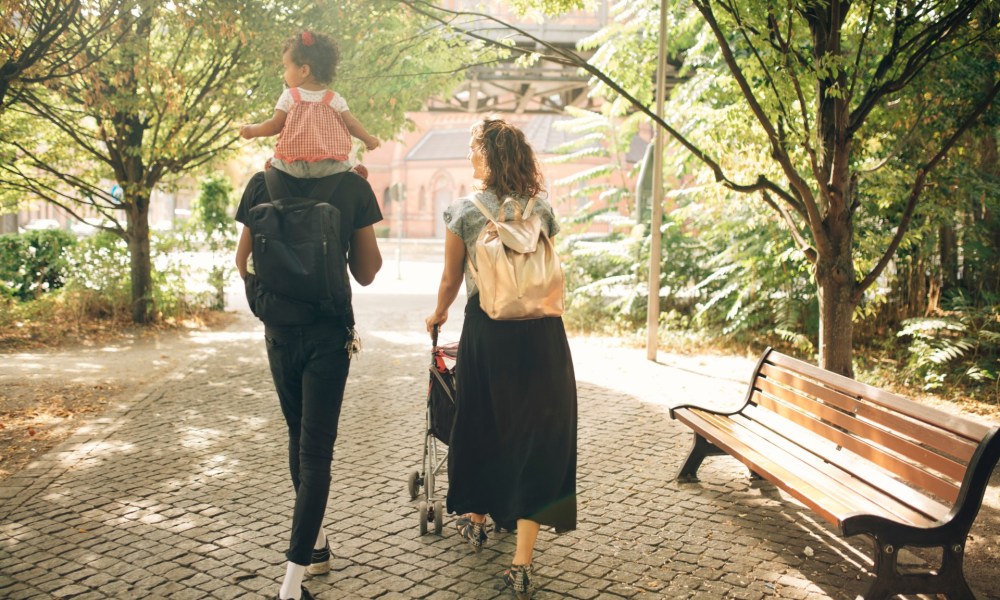 Parents with a child carrying a bag.