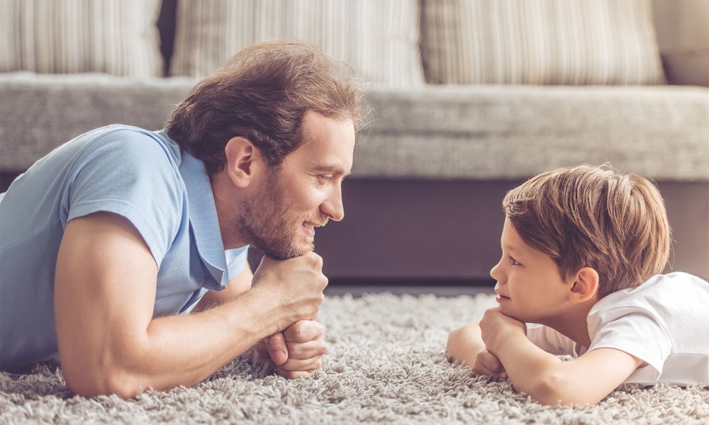 A child and parent on the floor talking.