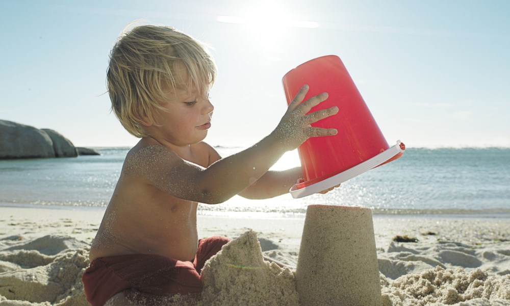 Boy making a sandcastle at the beach