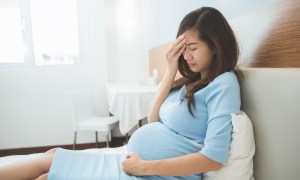 Pregnant woman on couch experiencing cramps