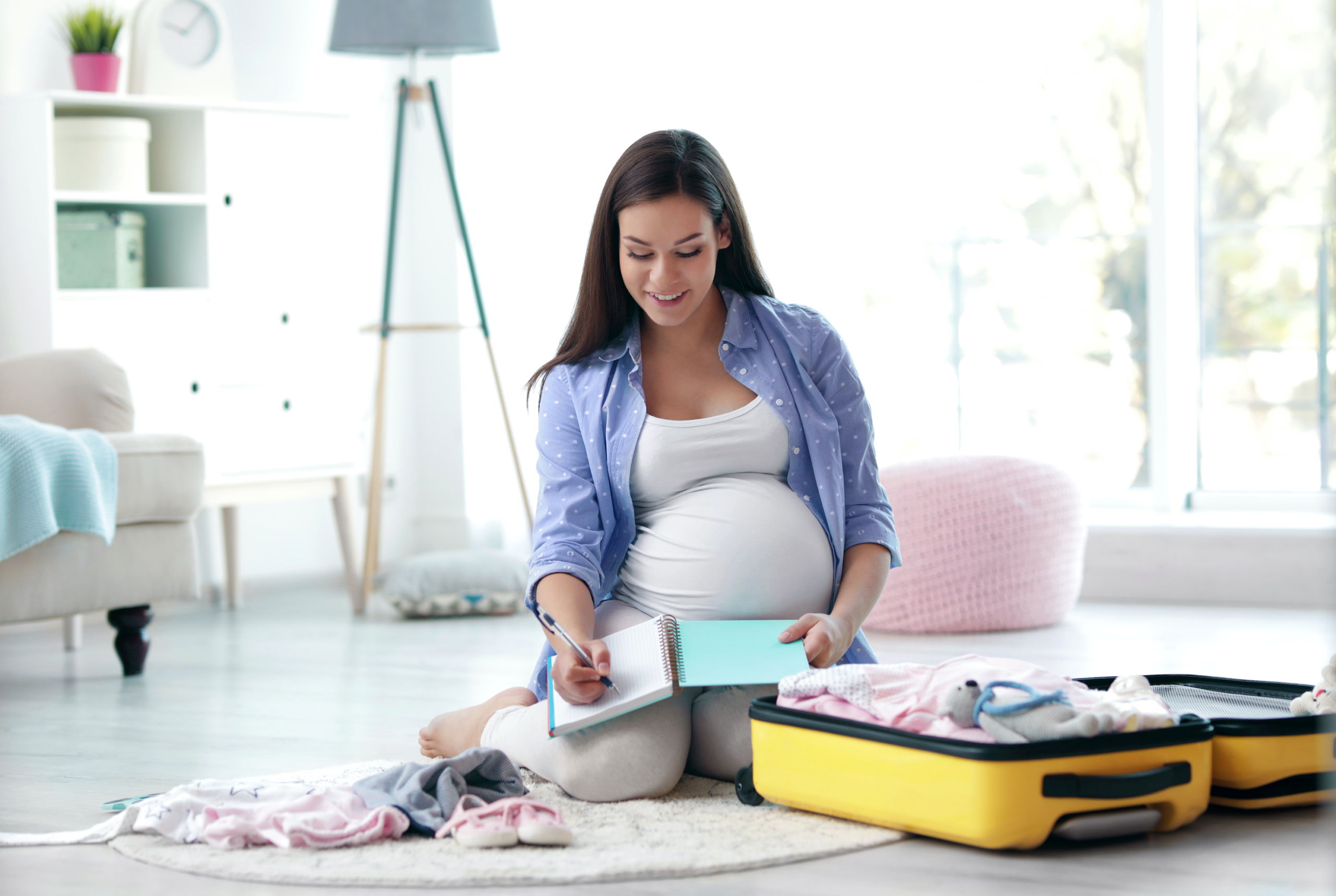 Pregnant woman packing a hospital bag.