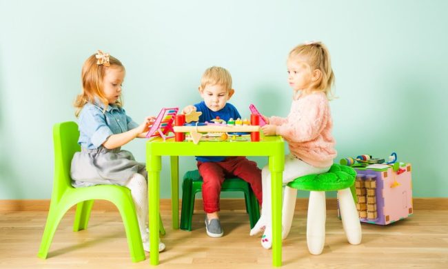 A group of young children at an activity table.