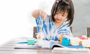 Little girl painting on the table