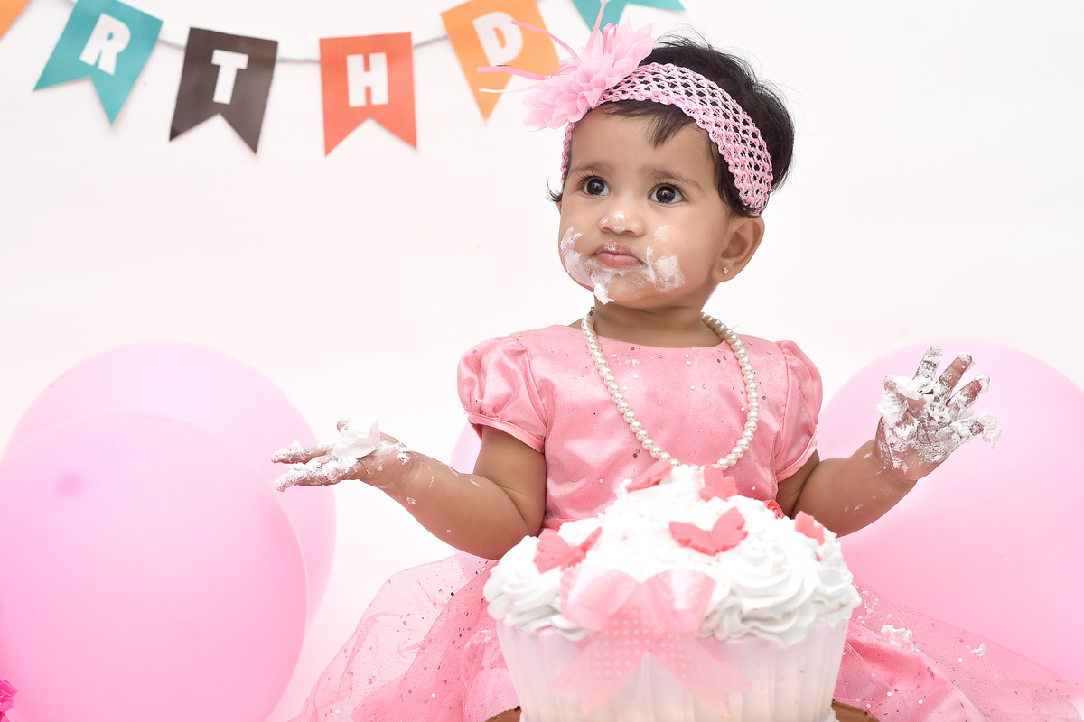 Baby girl covered with smash cake icing