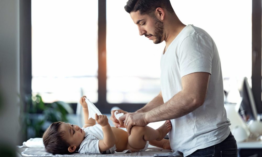 A dad changing baby's diaper