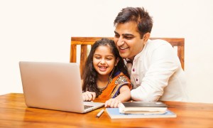 Dad using a laptop with his daughter