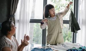 Little girl hanging up clothes for her grandmother