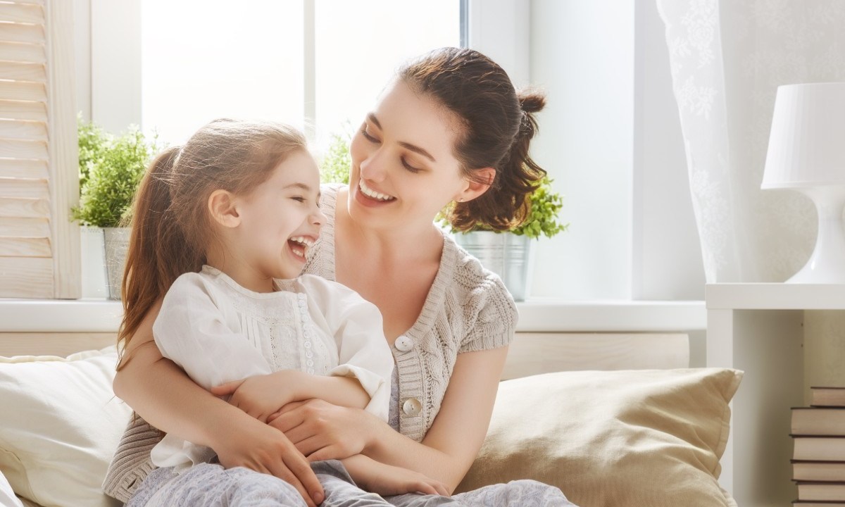 Mother laughing with her young daughter.