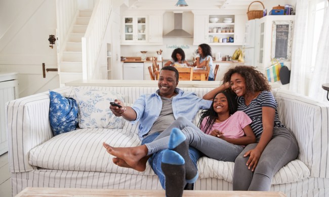 Parents watching TV with their teen daughter.