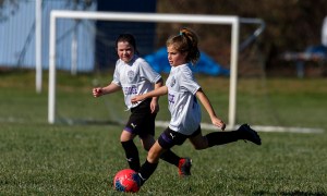 Two girls having fun playing travel soccer