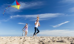 Family flying a kite on a beach