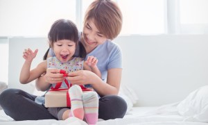 Mother and daughter opening a gift