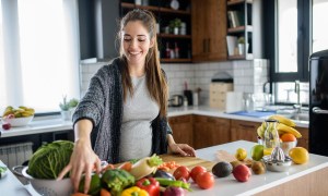 Pregnant woman cooking with fruits and vegetables