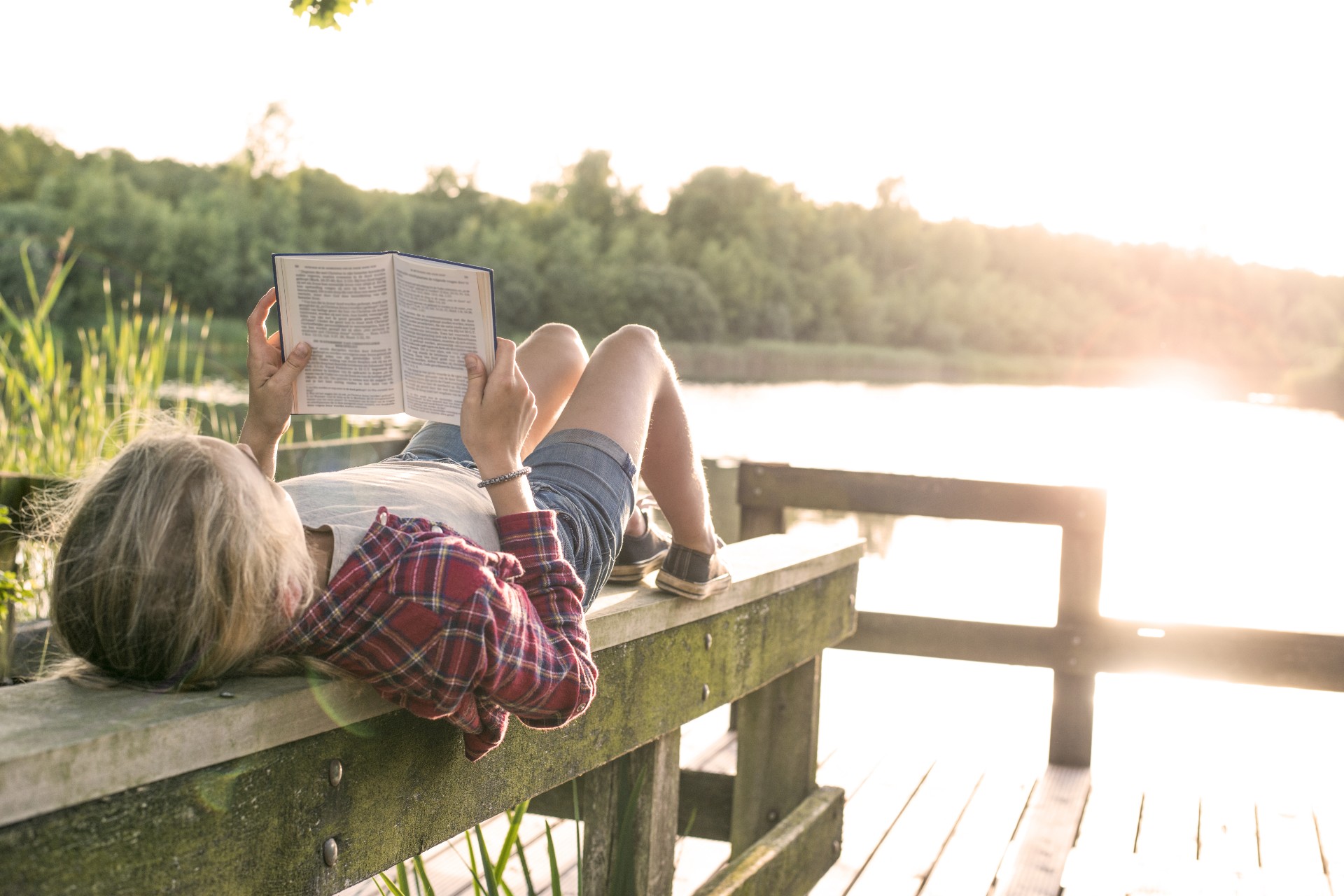 Teen girl enjoying a summer read on a dock