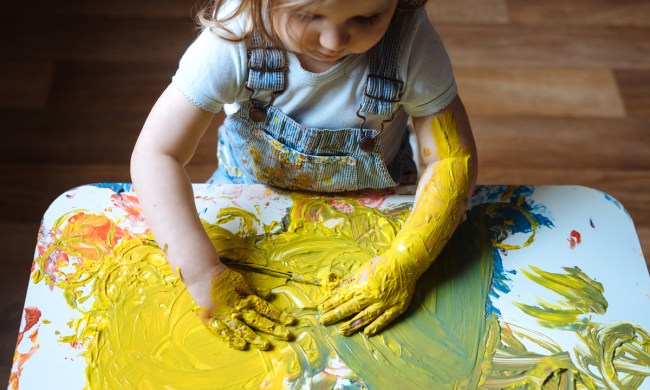 Toddler girl having fun finger painting