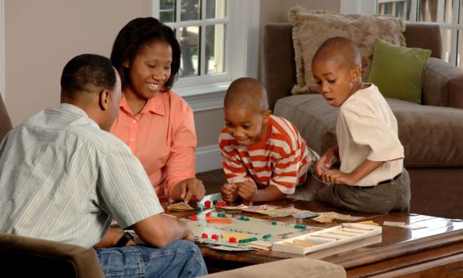 Parents with children playing a board game