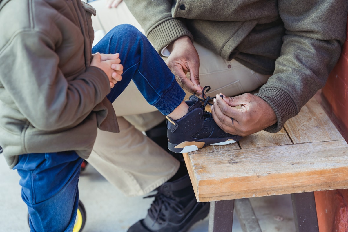 parent teaching a child how to tie shoes