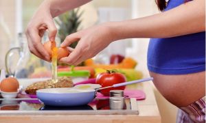 Pregnant woman making eggs.