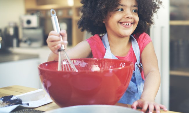 Young girl having fun cooking in the kitchen