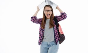 student holding laptop looking very stressed