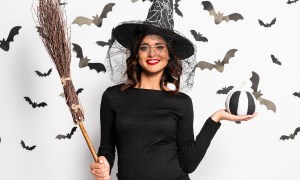 Happy pregnant mom wearing a maternity witch costume for Halloween