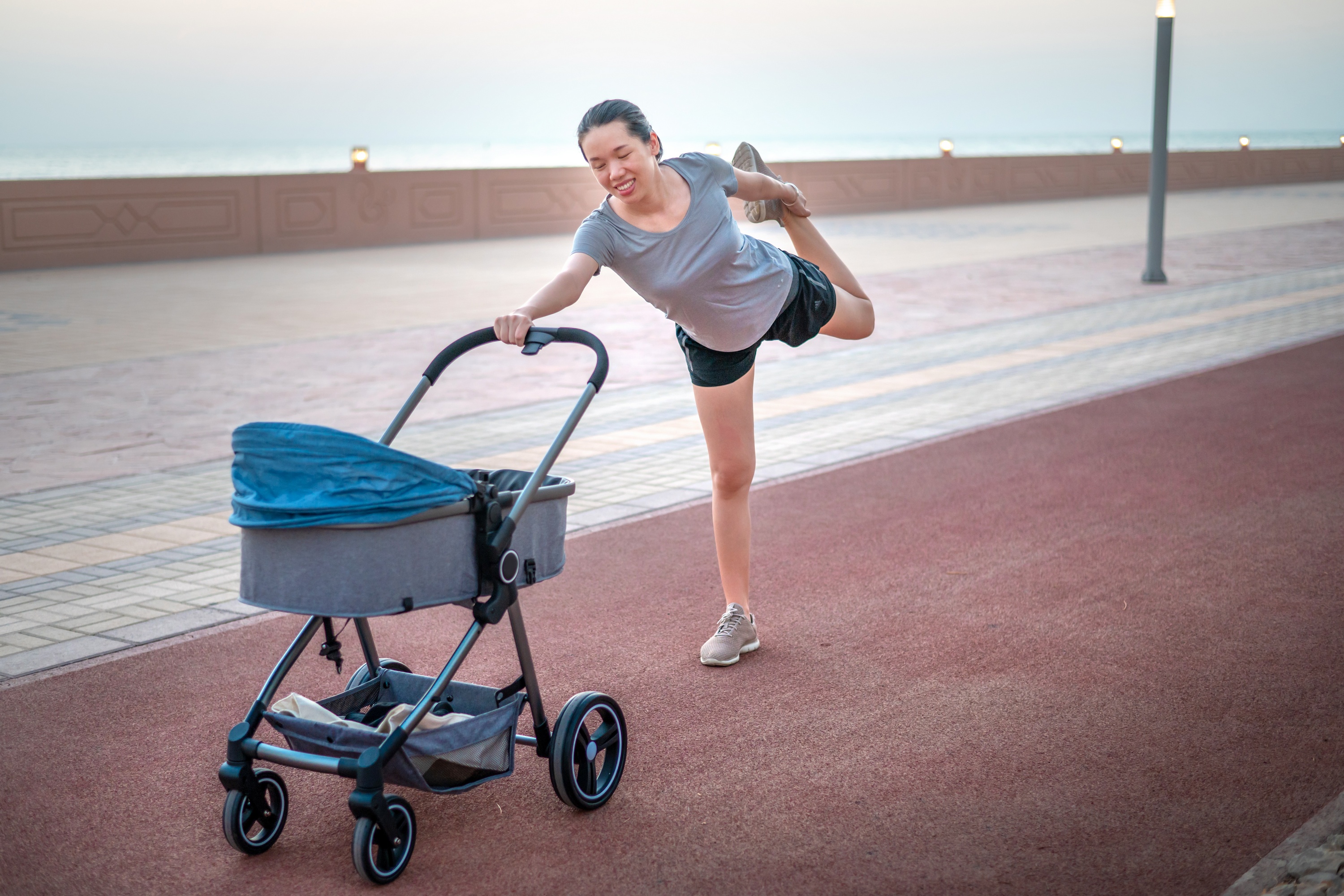 A mom working out while pushing her baby in a stroller.
