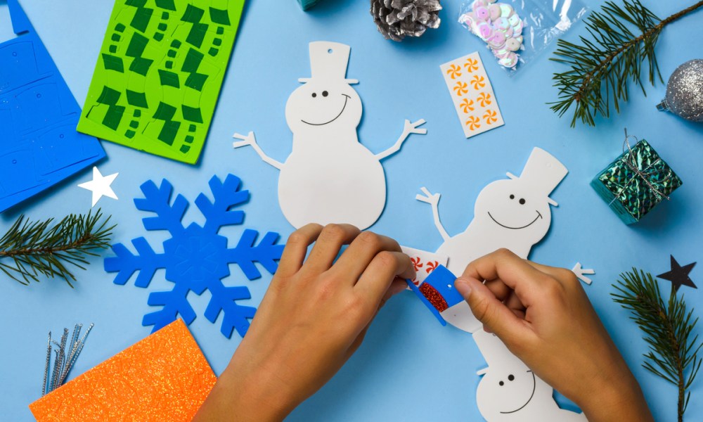 Hands putting together a snowman craft