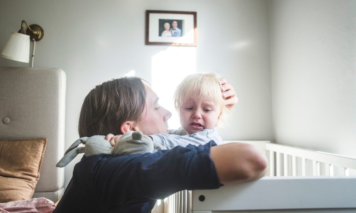 Toddler being comforted in bed after a nightmare.