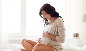 Pregnant woman on a bed.