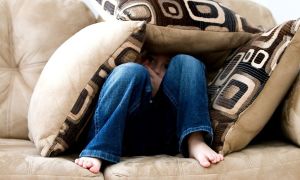 Boy hiding in couch cushions