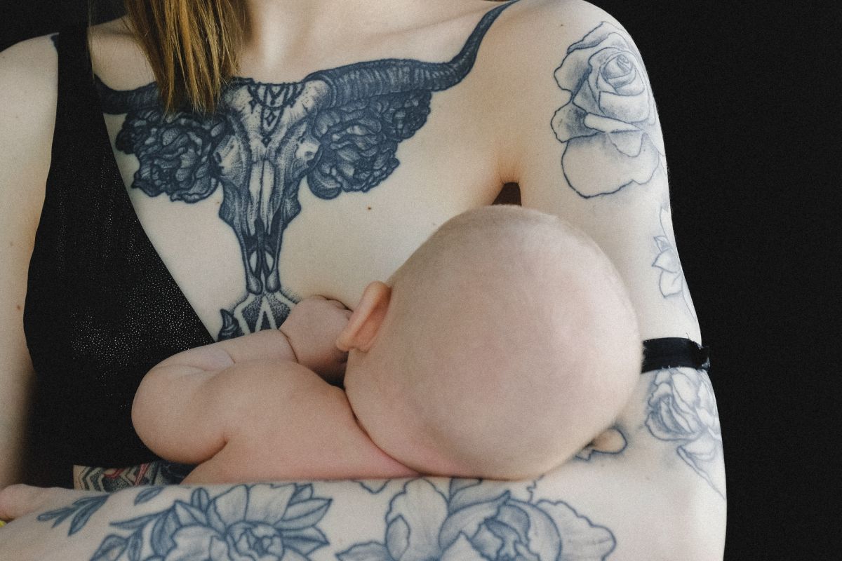 mom with tattoos breastfeeding