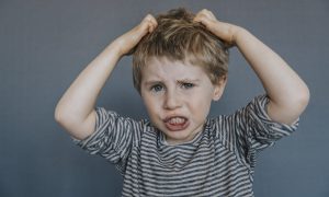 A little upset boy pulling at his hair