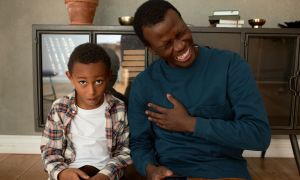 Father laughing at one of his dad jokes and his son not