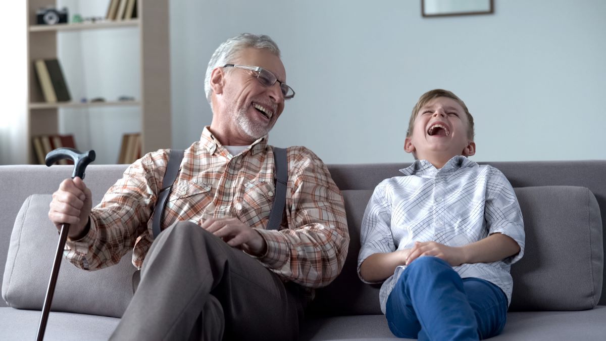 Grandpa and grandson laughing at a knock-knock joke