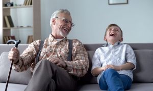 Grandpa and grandson laughing at a knock-knock joke