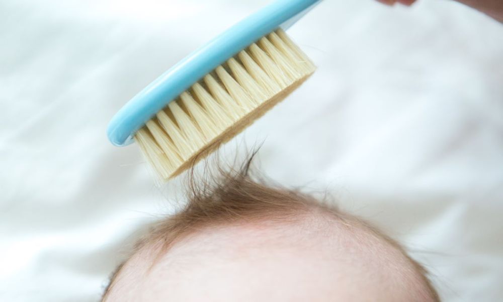 Mom brushing small amount of hair on a toddler