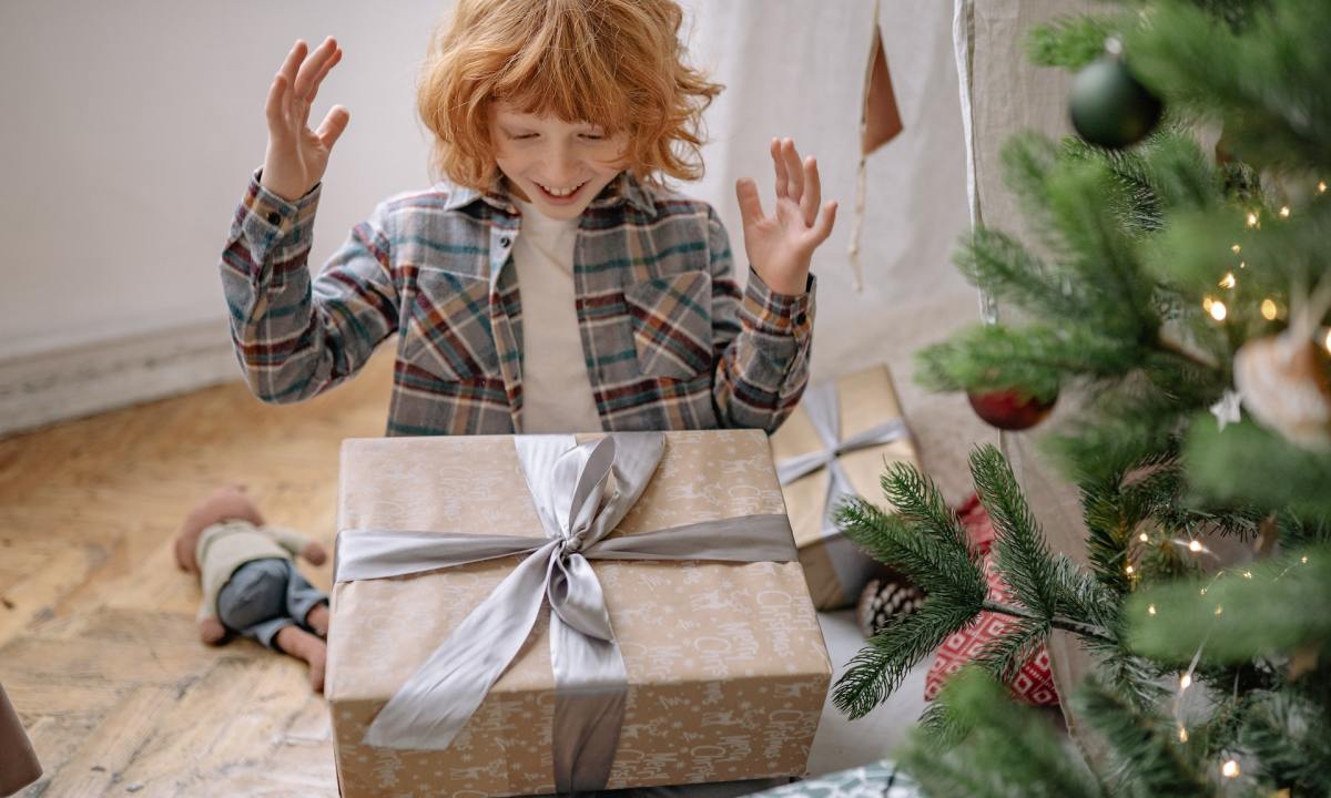 A happy child about to open a Christmas present.