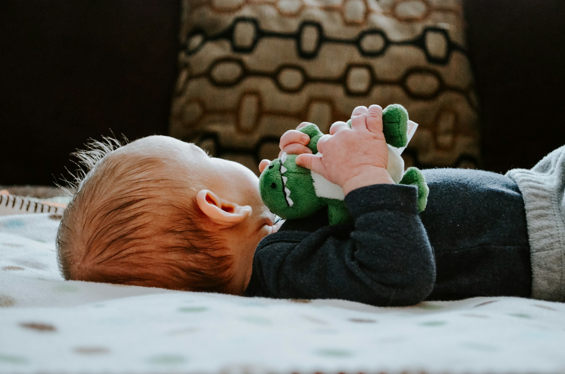 A baby lying down with their head turned away.