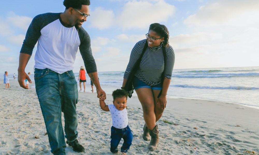 Family with their toddler on the beach.