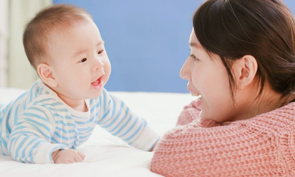 Happy baby having tummy time with mom.