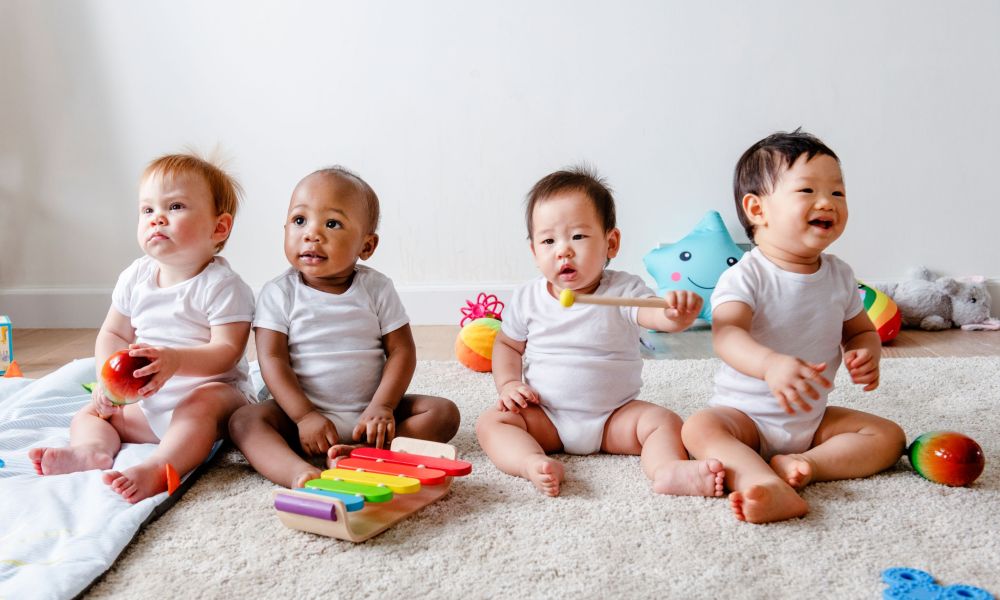 Four babies sitting together at daycare.