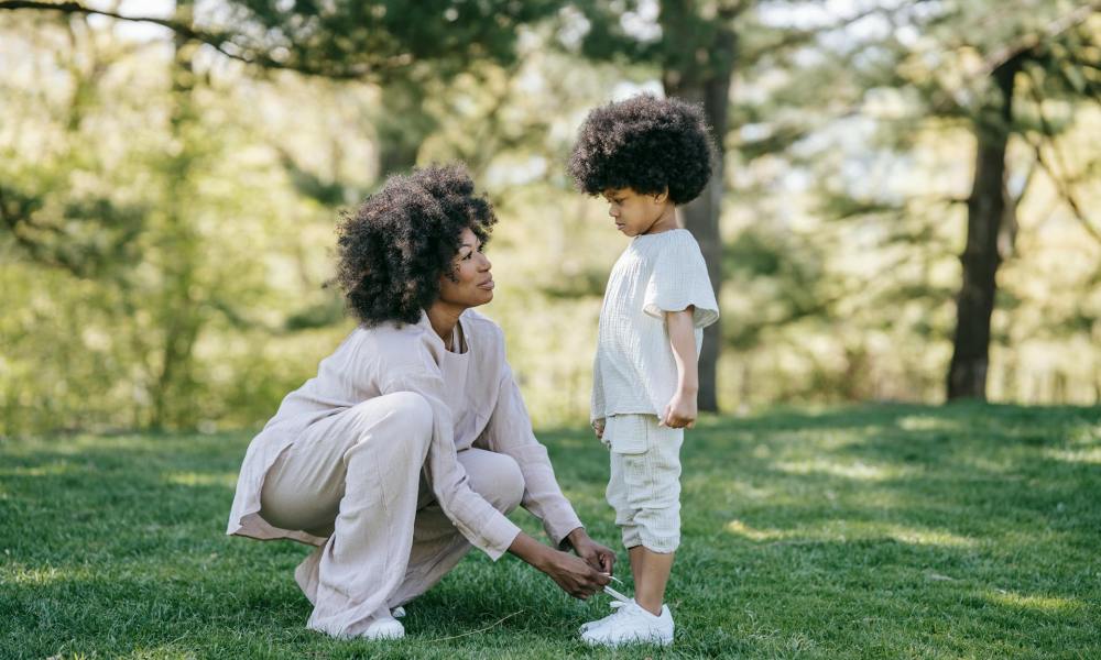 Mom tying her child's shoelaces