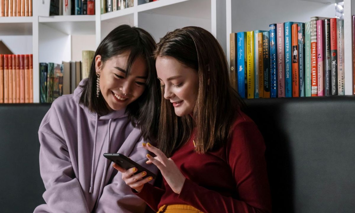 Two preteen girls looking a cell phone