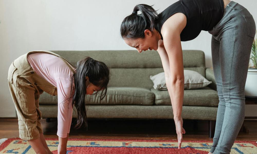 Mother and daughter doing yoga together