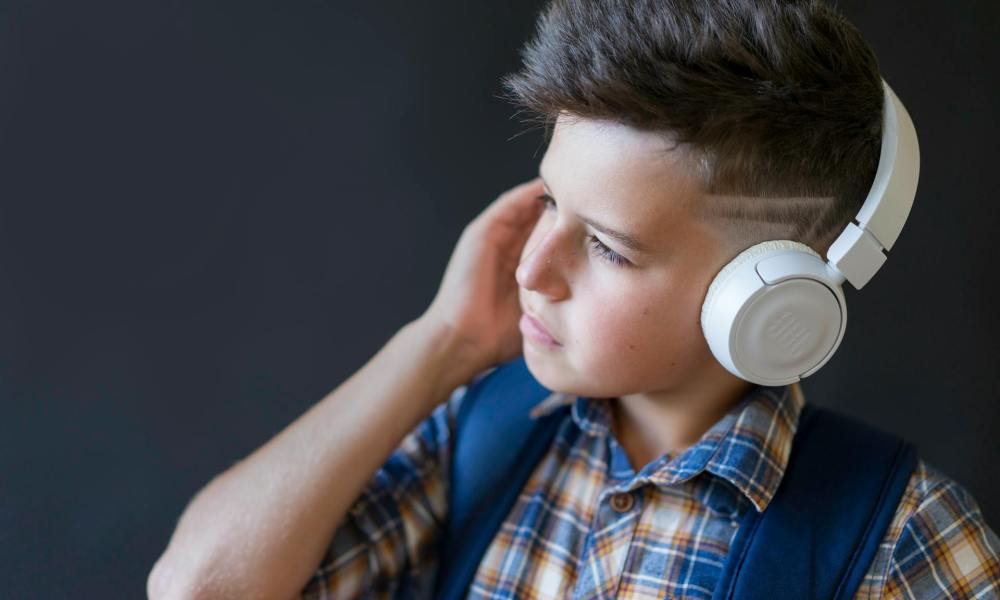 A boy with a faded haircut wearing headphones