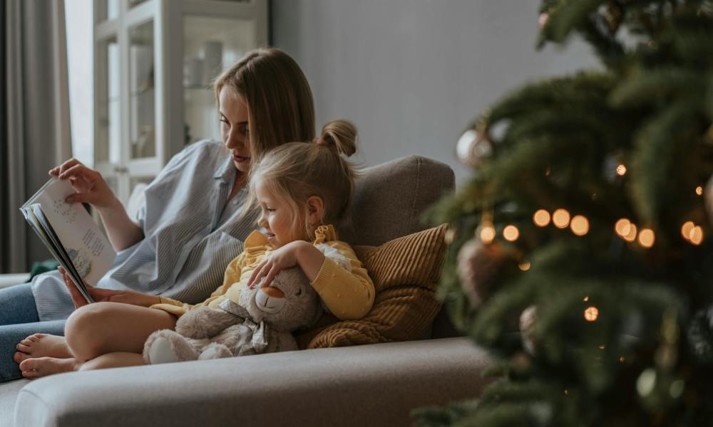 A mother reading a child a Christmas story.