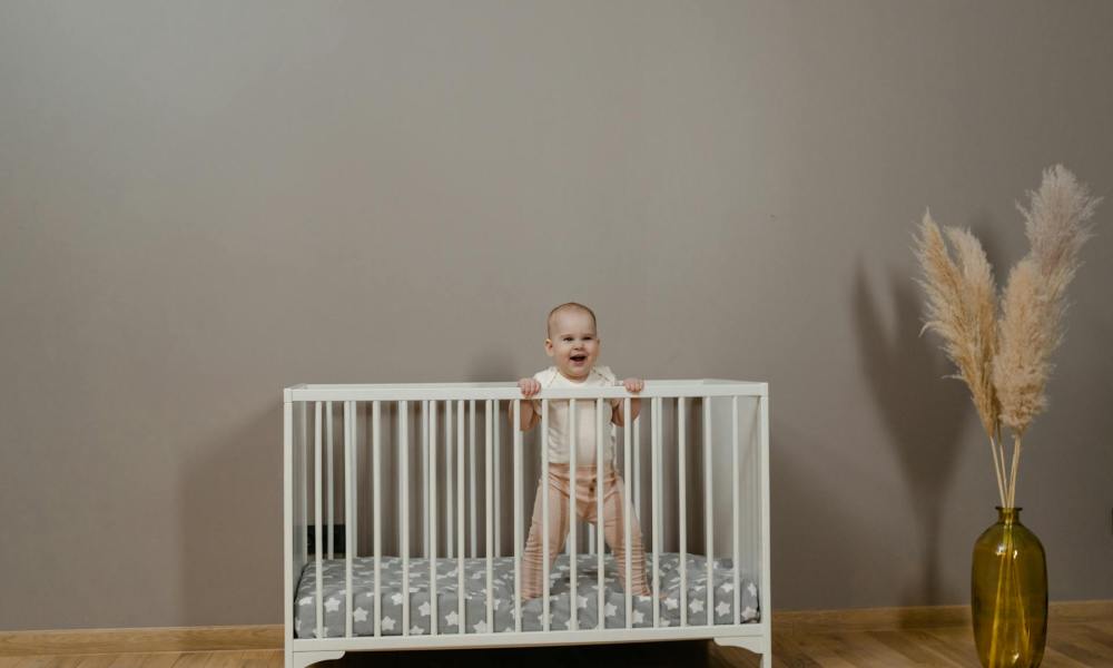 A baby standing in their crib